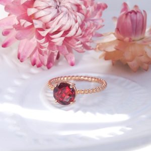 Bague femme en argent doré or rose sertie d'un grenat rouge rond sur un anneau perlé