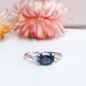 Bague pour femme en argent rhodié sertie d'une topaze blue london ovale et de petites topazes incolores autour